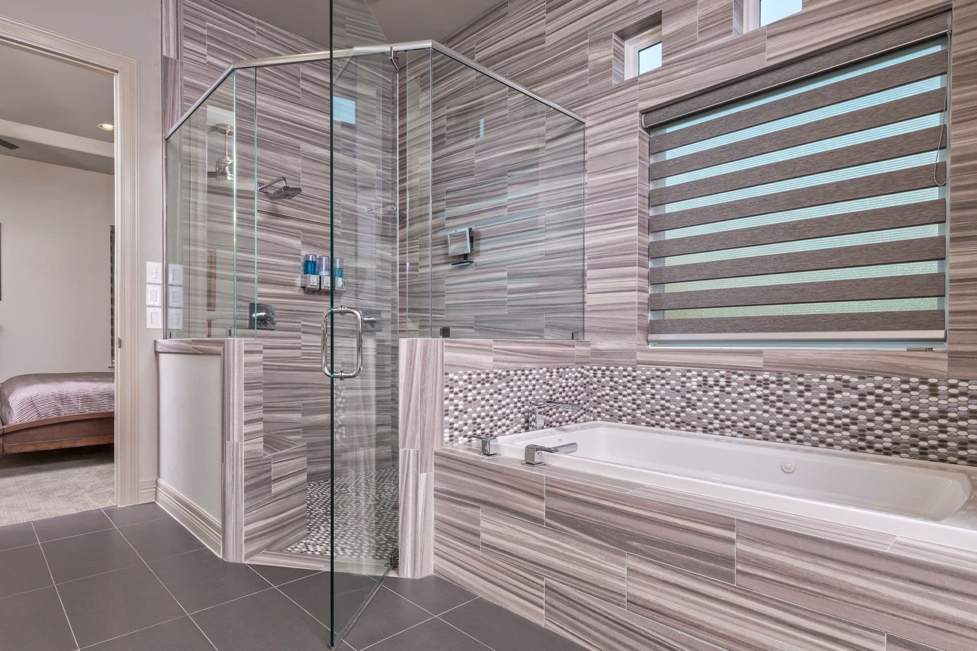 Frameless glass shower beside a tiled soaking tub