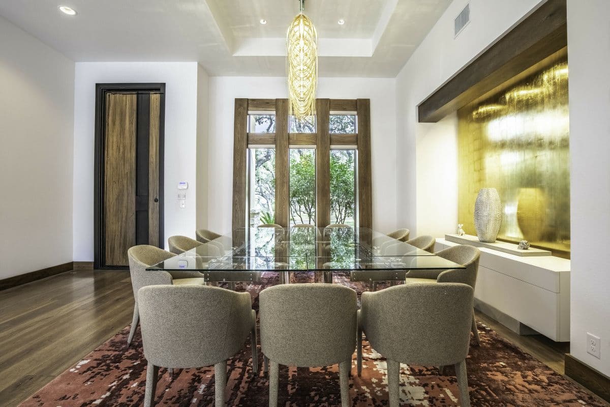 Dining room with a glass-topped table under a chandelier